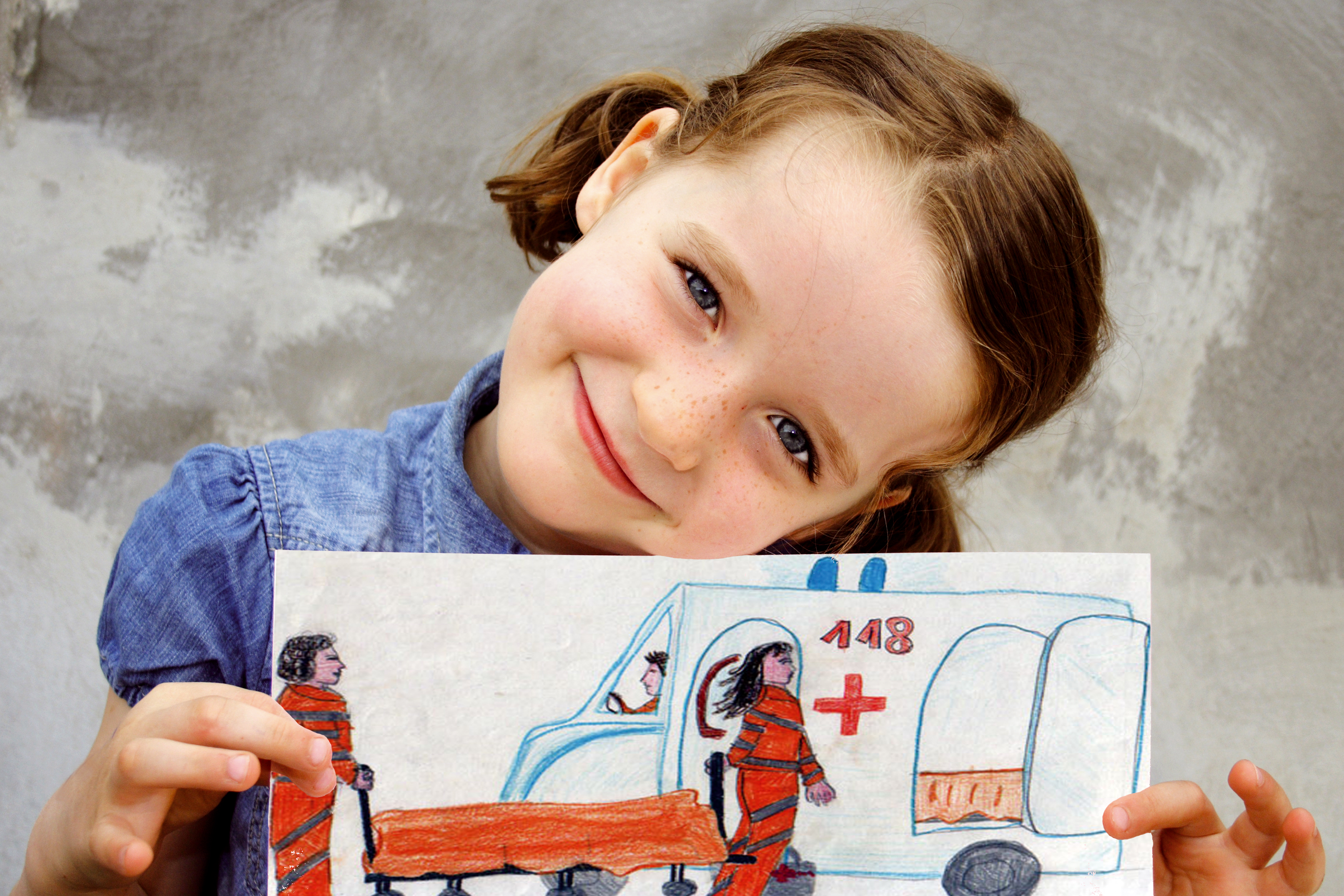 Bambina che mostra un disegno di un'ambulanzacoi soccorritori 